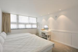 a white bedroom with a large bed and a desk at soul stay 2 in Busan
