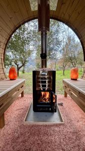 a fireplace sitting inside of a tent with two benches at Glamping Il Rifugio dei Marsi in Ascoli Piceno
