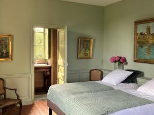a bedroom with a bed and a desk and a window at château de La Colinière - vue sur parc in Champtoceaux