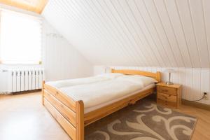 um quarto com uma cama de madeira e uma janela em Apartments Ilmtal-Jena em Jena