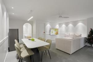 a white dining room with a white table and chairs at soul stay 2 in Busan