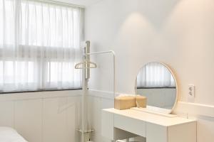a white bathroom with a mirror and a sink at soul stay 2 in Busan +47 photos