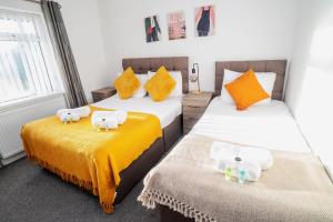 a bedroom with two beds with towels on them at Glenroy House Swansea in Swansea