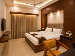 a hotel room with a bed and a television at Hotel Unnati Stay Inn Vijayapura By HRG in Bijāpur +20 photos