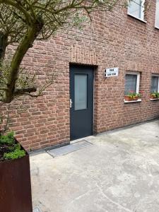 a brick building with a black door and a sign at Apartment "New York - Prag" in Korschenbroich
