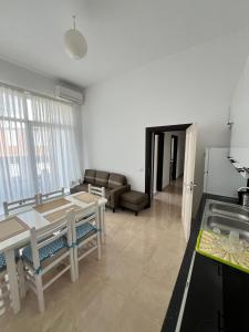 a kitchen and living room with a table and a couch at Seaside Escape in Draç