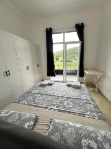 two beds in a room with a window at Seaside Escape in Draç