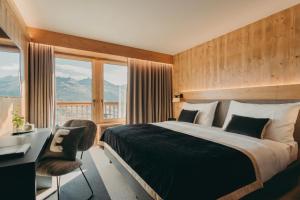 ein Schlafzimmer mit Bett, Schreibtisch und Fenstern in der Unterkunft Eringer Hotel in Hérémence + 51 Fotos