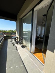 a balcony with a table and chairs and a view at Hug and Fly Apartment in Skopje