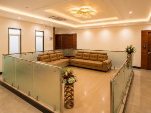 a lobby with couches and chairs in a building at Hotel Unnati Stay Inn Vijayapura By HRG in Bijāpur