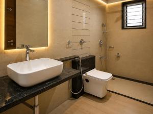 a bathroom with a sink and a toilet at Hotel Unnati Stay Inn Vijayapura By HRG in Bijāpur