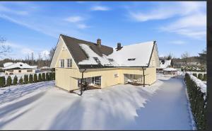 a house is covered in snow with a fence at Kasekuma House with all comforts well located in Otepää