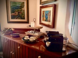 a wooden cabinet with cups and dishes on top of it at La Locandiera affittacamere in Scilla