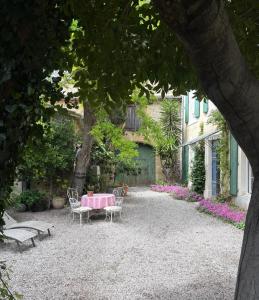 a garden with a table and chairs and a building at Écurie de l oasis in Caux