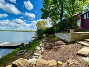 a house on the shore of a body of water at Lakefront Glamping Cottage- Fishing-Swimming-Boating in Watertown