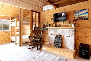 a room with a fireplace in a log cabin at Lakefront Glamping Cottage- Fishing-Swimming-Boating in Watertown