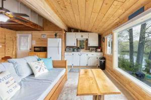 a living room with a couch in a tiny house at Lakefront Glamping Cottage- Fishing-Swimming-Boating in Watertown