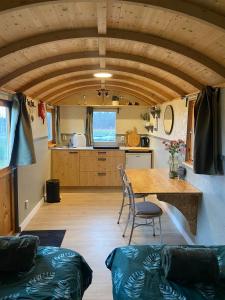 a kitchen and dining room with a table and chairs at Shepherd Hutten Hunsel in Hunsel