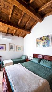 two beds in a room with wooden ceilings at Il FONTANONE in Veiano