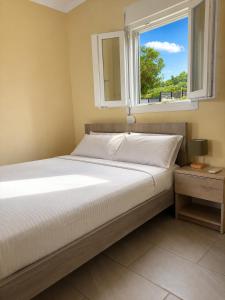 a bed in a room with a window at Ouranoupolis View Point in Ouranoupoli