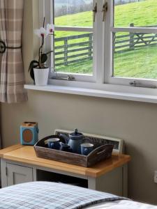 a tray of dishes on a table next to a window at Huntshaw Stables in Earlston