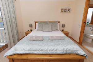 a bedroom with a large bed with two pillows at Bellevue House, Shetland Islands in Whiteness