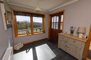 a kitchen with a large window and a wooden cabinet at Bellevue House, Shetland Islands in Whiteness