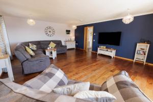 a living room with a couch and a flat screen tv at Bellevue House, Shetland Islands in Whiteness +79 photos