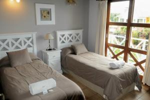 a bedroom with two beds and a window with a door at Refugio de Mar in Miramar +99 photos