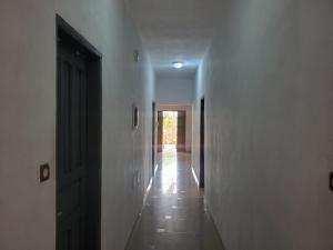 an empty hallway with a hallway leading to a door at Au cœur de Ouidah in Ouidah +9 photos