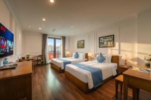 a hotel room with two beds and a flat screen tv at Hanoi Sail Hotel in Hanoi