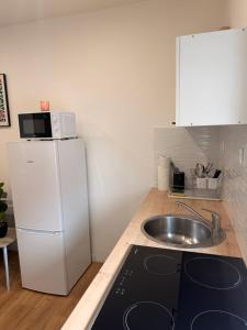 a small kitchen with a sink and a refrigerator at Escale Confort A1-2 Chambres Stationnement Facile in Roye +15 photos