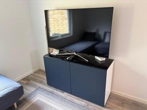 a living room with a flat screen tv on a dresser at Modern villa apartment with free parking in Sollentuna