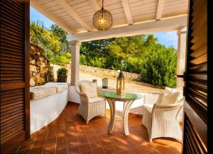 an outdoor patio with a table and chairs at Villa Luna Rossa con piscina in San Teodoro