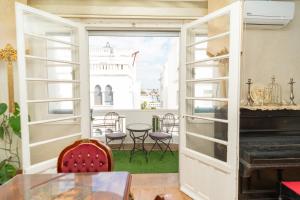 a room with a door open to a patio with a piano at Royal Moroccan Suite Central Tangier in Tangier