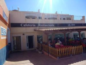 a building with a restaurant with people sitting in chairs at Comfortable apartment with balcony and huge pool in Sucina