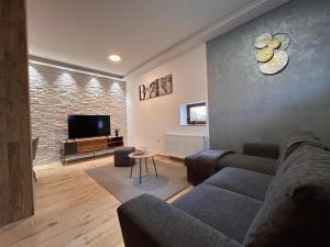 a living room with a couch and a tv at BT Apartman in Miercurea-Ciuc