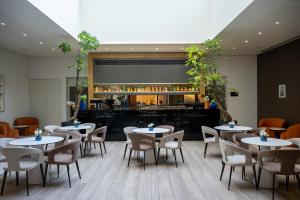a restaurant with tables and chairs and a bar at Leonardo Plaza Netanya Hotel in Netanya