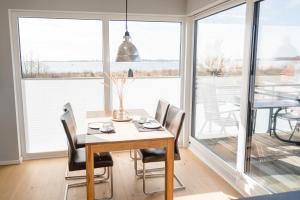 a dining room with a table and chairs and a large window at Ferienhaus Brückenblick 12 a in Fehmarnsund