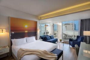 a hotel room with a bed and a balcony at Leonardo Plaza Netanya Hotel in Netanya +28 photos