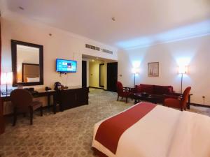 a hotel room with a bed and a living room at Grand Regal Hotel in Doha