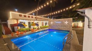 a swimming pool at night with lights above it at Second Home Stays at Arnav Cottages Alibag in Alibaug +15 photos