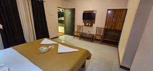 a hotel room with a bed and a dining room at Second Home Stays at Arnav Cottages Alibag in Alibaug