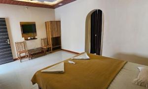 a bedroom with a bed with a table and chairs at Second Home Stays at Arnav Cottages Alibag in Alibaug