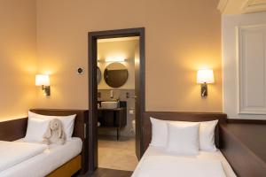 a bedroom with two beds with a teddy bear sitting on them at Altstadthotel Arch in Regensburg