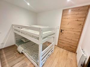 a white bunk bed in a room with a door at Gîte d'Eléonore in Rupt-sur-Moselle