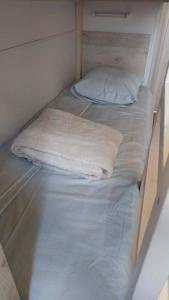 two beds in a room with white sheets and pillows at La roulotte des écuries in Saint-Pierre-de-Chemillé