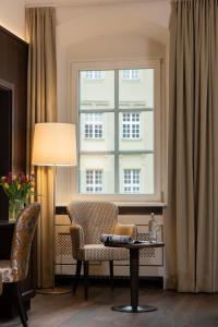 a living room with a table and a window at Altstadthotel Arch in Regensburg