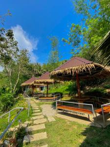 a group of benches and umbrellas in a park at Busai Dream Falls Resort in Loboc