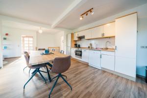 a kitchen and dining room with a wooden table and chairs at Landhaus Mira in Witzenhausen